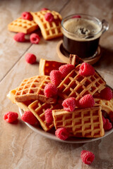 Belgian waffles with raspberries and black coffee.