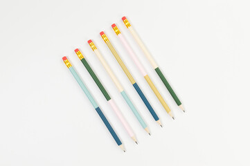 Top view of colorful pencils on white background. School, office, art wallpaper. Flat lay, copy space.