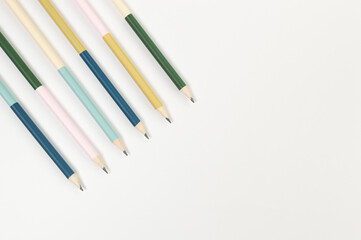 Obraz premium Top view of colorful pencils on white background. School, office, art wallpaper. Flat lay, copy space.