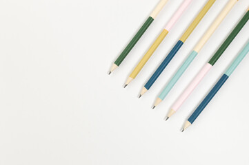 Top view of colorful pencils on white background. School, office, art wallpaper. Flat lay, copy space.
