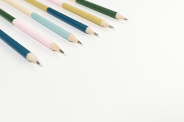 Top view of colorful pencils on white background. School, office, art wallpaper. Flat lay, copy space.