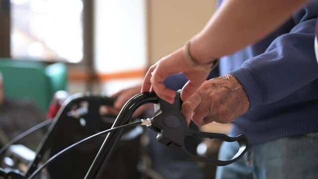 Nurse helping old man to walk at nursing home with walker. Young nurse helping senior patient using a walking frame to walk in hospital corridor. High quality 4k footage