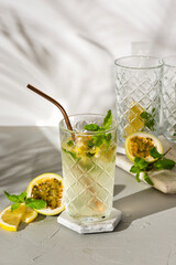 A refreshing summer drink or alcoholic cocktail with passion fruit, ice and lemon on a sunny day. A fresh healthy cold lemonade drink. Sparkling water with lemon.