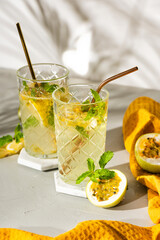 A refreshing summer drink or alcoholic cocktail with passion fruit, ice and lemon on a sunny day. A...