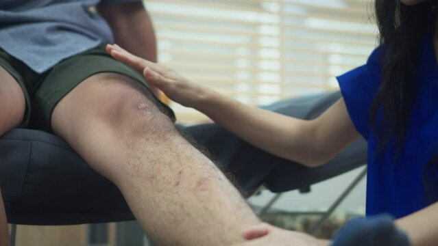 Close up shot of physical therapist checking knee flexion of athlete patient at medical examination room