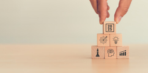 Business goal, plan, action in 2025. Wooden cubes with icon business strategies, action plan, goal, increase sale, process, game plan. Business strategies and achieving goals. Sustainable development.