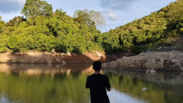 a man who was fishing on the edge of the lake