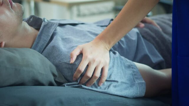 Female physiatrist examining male patient frozen shoulder symptoms in a rehabilitation clinic