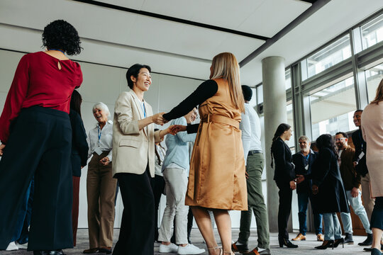 Women greeting and mingling at an office event with colleagues