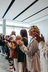 Successful team clapping at workshop event in modern office