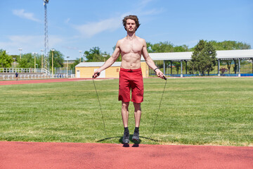 Obraz premium shirtless man jumping rope, trains outdoors