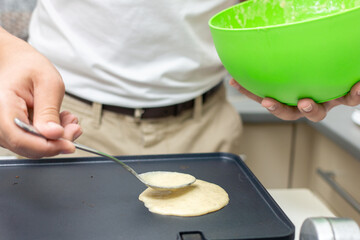 Young smiling happy confident  baker man  in the kitchen. Process cooking food concept. 