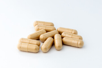 Close-up herbal capsules isolated in bright background. Herbal medicine for alternative therapy concept.