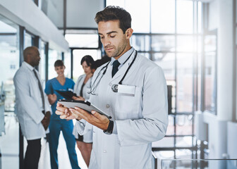 Doctor, medical and man with tablet in hospital healthcare, Telehealth and research for diagnosis prescription. Male expert, digital and reading, information history and surgery schedule at clinic