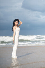 Portrait of a woman in white dress relaxing on the beach
