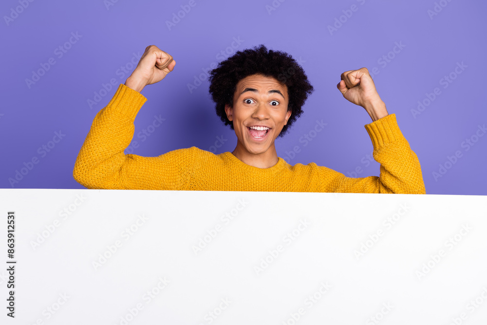 Wall mural Photo of cheerful glad man wear stylish yellow clothes fists hands empty space isolated on purple color background