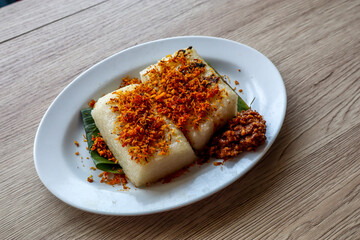 Ulen Traditional Food from Lembang, Indonesia, Grilled Sticky Rice, Coconut Flakes, and Peanut Sauce