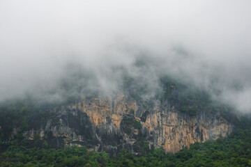 Thick fog on dramatic cliffs. Beautiful landscape after the rain