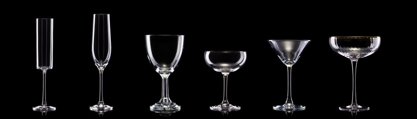 Set of different empty glasses for drinks and cocktails on black background