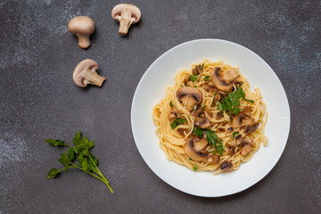 Mushroom Spaghetti Pasta and cream sauce on rustic, dark background, top view, copy space. Homemade italian pasta with champignon mushroom. 