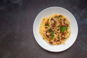 Mushroom Spaghetti Pasta and cream sauce on rustic, dark background, top view, copy space. Homemade italian pasta with champignon mushroom. 