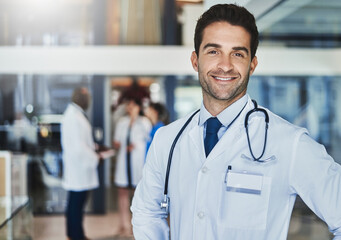 Fototapeta premium Doctor, face and pride in hospital for healthcare, wellness or medical experience with stethoscope. Man, portrait and smile as surgeon in health facility with confidence for cardiology or medicine