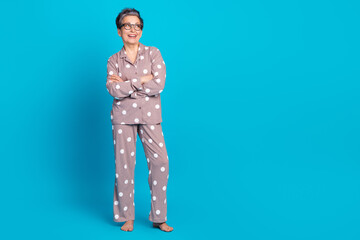 Photo of cheerful pensioner woman wear stylish pajama look poster empty space isolated on blue color background