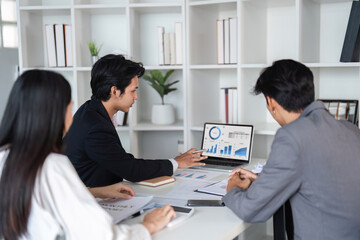 Business Team Collaborating in Modern Office, Analyzing Data on Laptop, and Sharing Ideas for Project Development