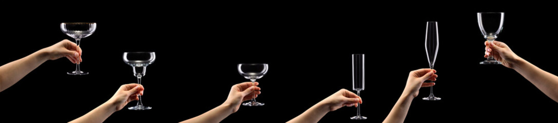 Woman hand holding empty cocktail glass isolated on black background