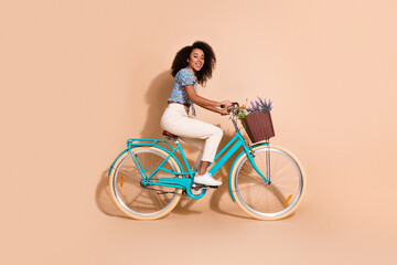 Full length photo of cheerful pretty lady dressed blue blouse riding bike empty space isolated...