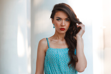 Fototapeta premium Beautiful young fashion fresh glamor woman in vintage fashionable dress with earrings walking in the city on white background