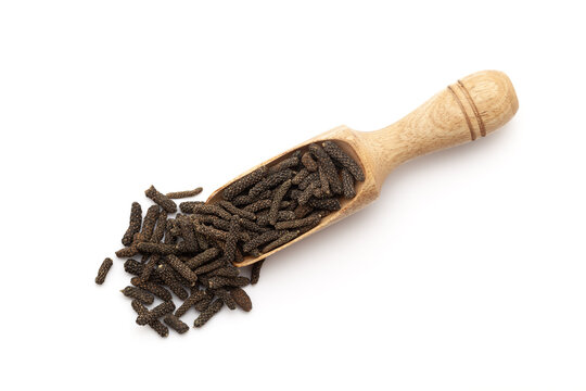 Top view of a wooden scoop filled with Organic Long pepper (Piper longum) fruit. Isolated on a white background.