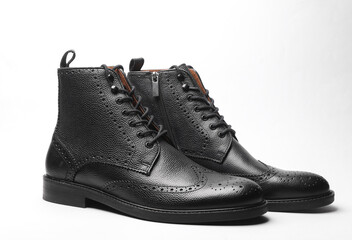 Stylish black leather men's brogue boots on a white background