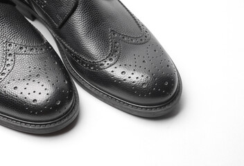 Stylish black leather men's brogue boots close up on a white background