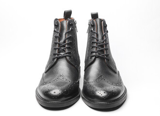 Stylish black leather men's brogue boots on a white background
