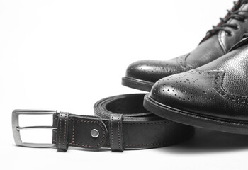 Men's black leather brogue shoes with belt on a white background. Top vew
