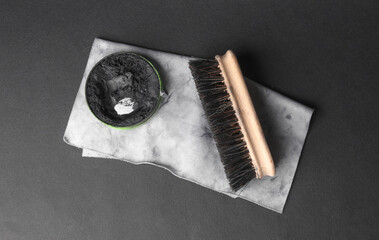 Shoe polish, rag and brush on a black background. Leather shoe care