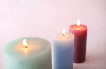 Flaming candles on a pink background. Romantic atmosphere