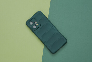 Smartphone in protective case on a green background