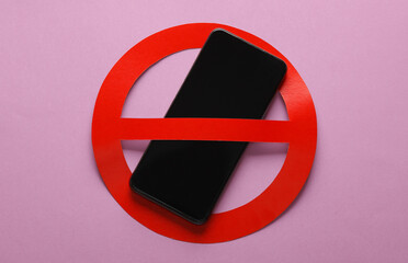 Smartphone with red prohibition sign on pink background. Ban.