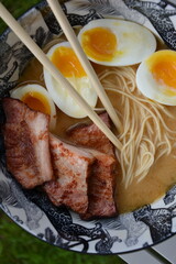 Bowl of miso ramen soup on table outside outdoor on patio lawn garden