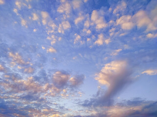 Many colourful clouds in sky, beautiful background. Evening sunset sky with small bright clouds, calm atmosphere