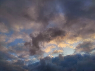 Dark dramatic clouds in sky. Evening photo of dark colorful clouds illuminated by setting sun