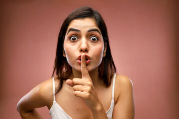 Fototapeta premium A Stunning Woman In White Top Placing Her Finger On Her Lips