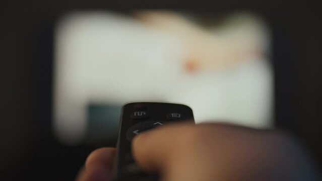 The modern man spends the evening in the cozy atmosphere of a home theater. Sitting on the sofa, he uses the remote control to switch TV channels and select interesting programs to watch