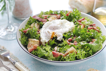 A bowl with salad lyonnaise served for lunch	