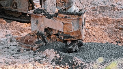 Construction Site Pale Driver Equipment Drill Covered in Fresh Concrete Cement during Foundation...
