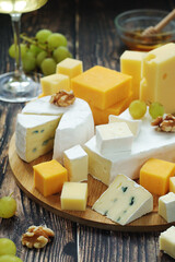 Several types of cheese served with honey and grapes	