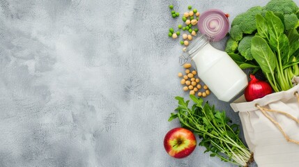 A mesh bag filled with leafy greens sits on a grey countertop surrounded by fresh produce like potatoes, onions, and chickpeas.