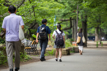 公園を歩く高校生男女